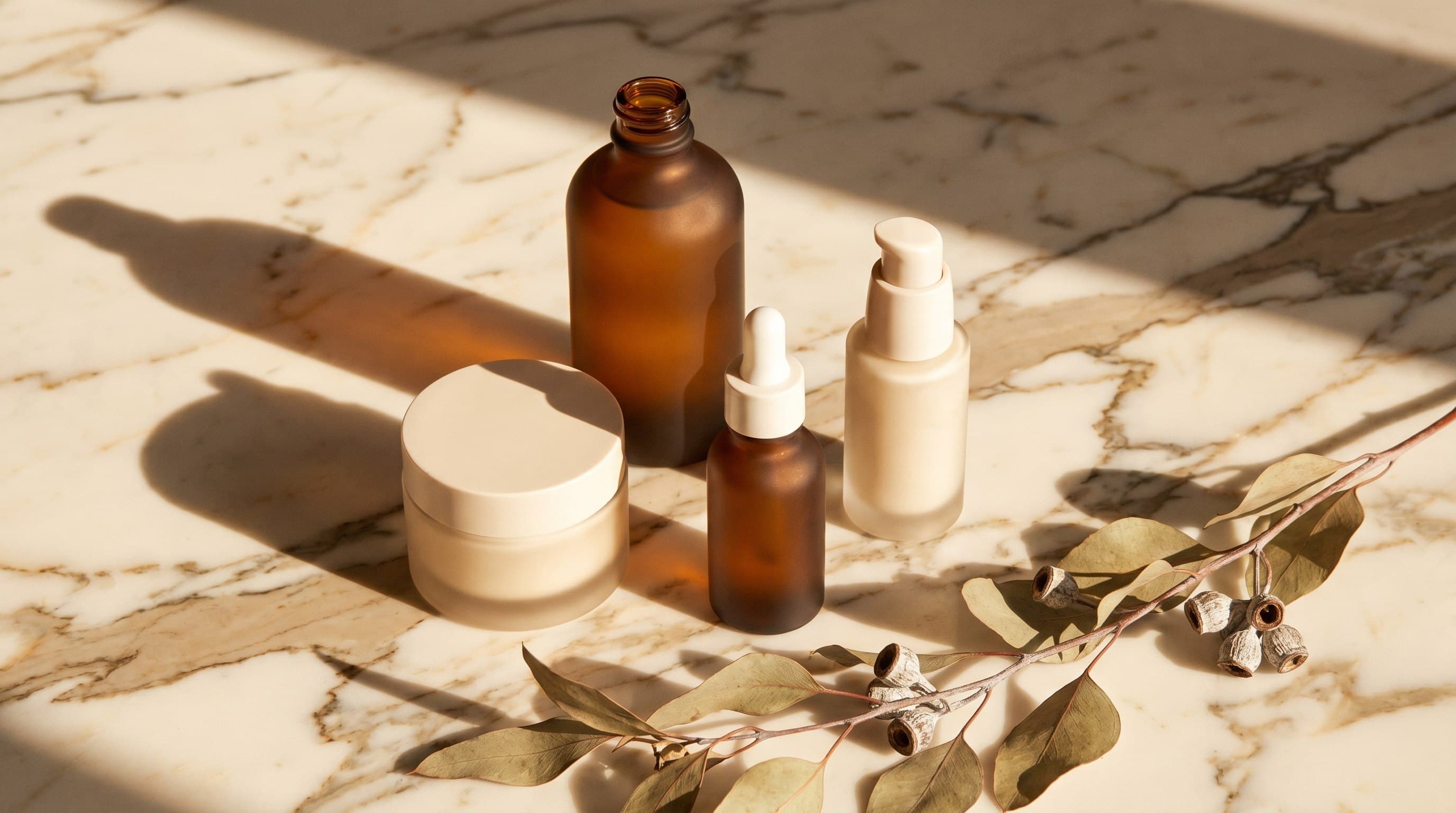 The Devereaux Apothecary — frosted-glass formulations on marble with a eucalyptus branch